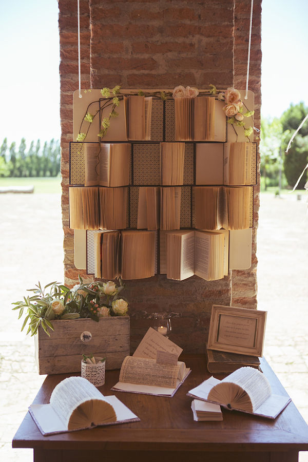 Guestbook matrimonio a tema libri e chiavi: pannello con tanti libri ed un tavolino con tanti bigliettini su cui scrivere il messaggio di buon augurio da inserire in altri libri aperti a ventaglio